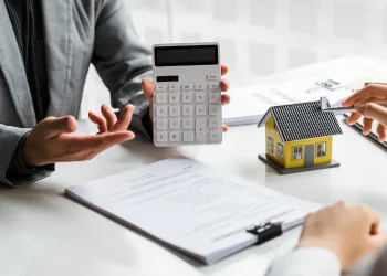 a person holding a calculator and a house