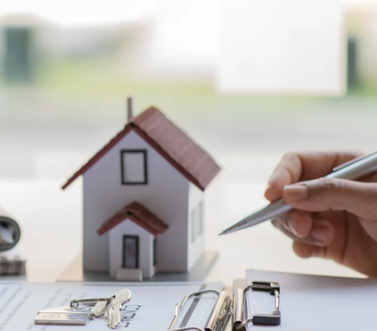 a person holding a calculator and a house model