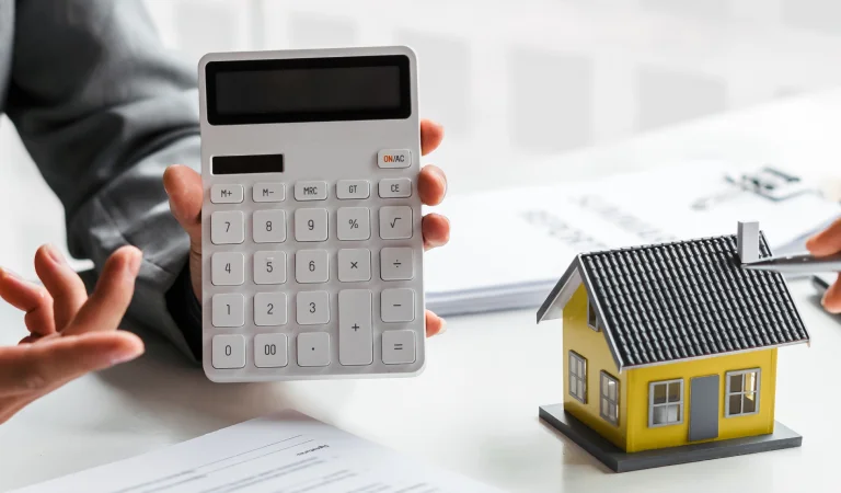 a person holding a calculator and a house