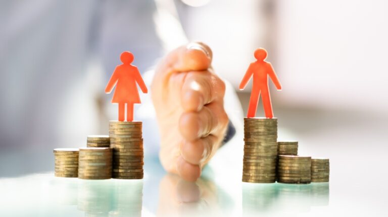 Man and woman on stacks of coins being divided