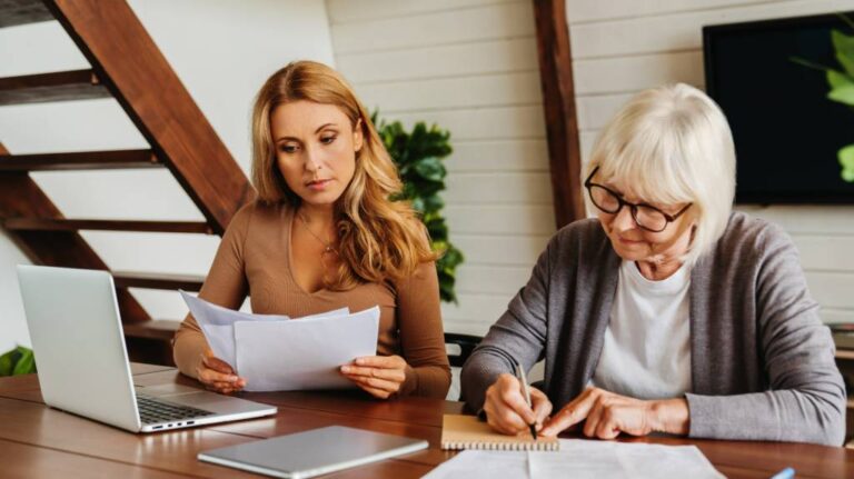 adult mother and daughter reviewing documents