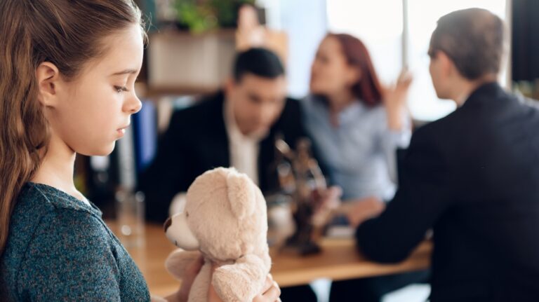 little sad girl listens to her parents arguing in a lawyer's office