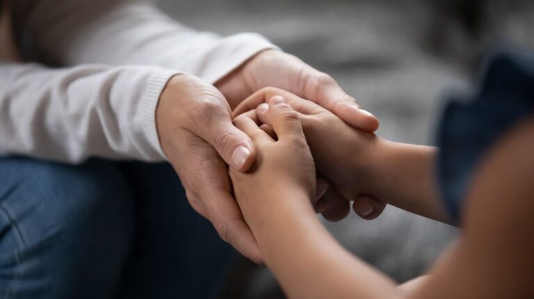 parent holding hands of little kid girl