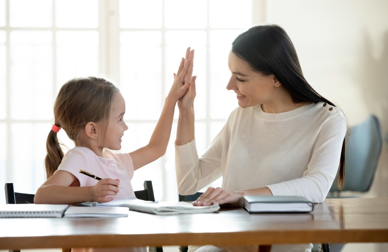 Happy little daughter high fives her mother