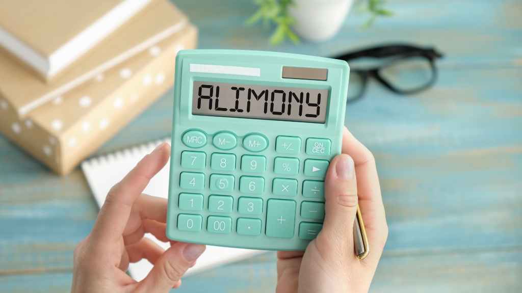 Word ALIMONY written on calculator on office table
