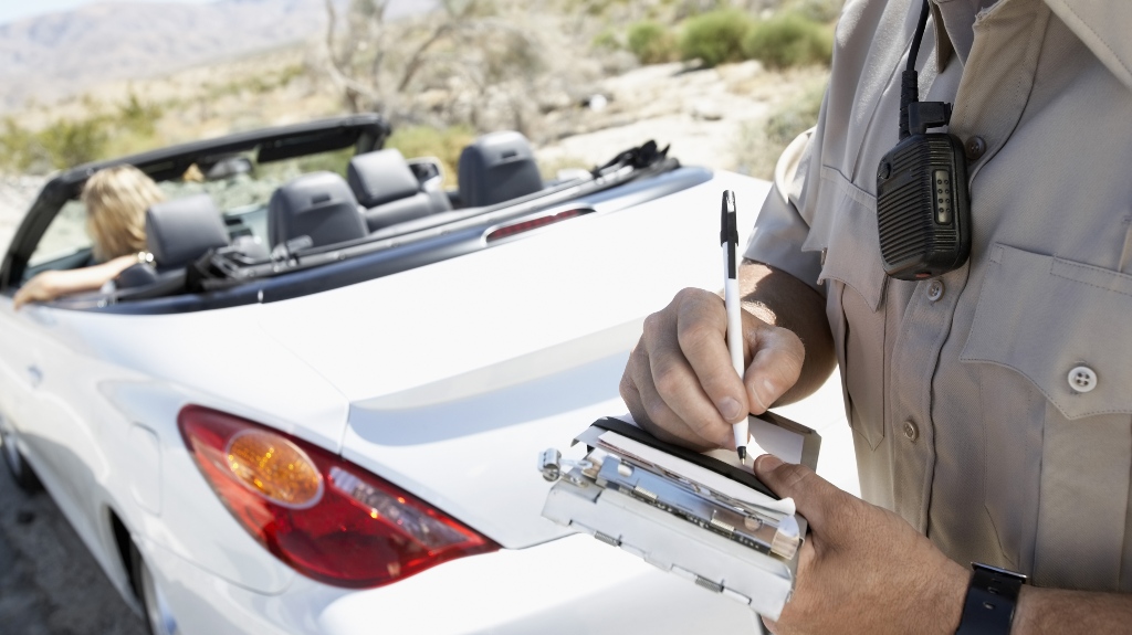 traffic policeman issues a speeding ticket to a woman