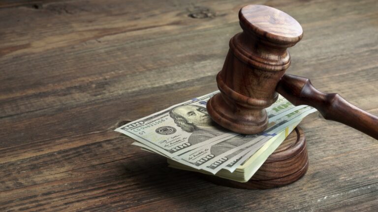 judge's gavel on dollar bills