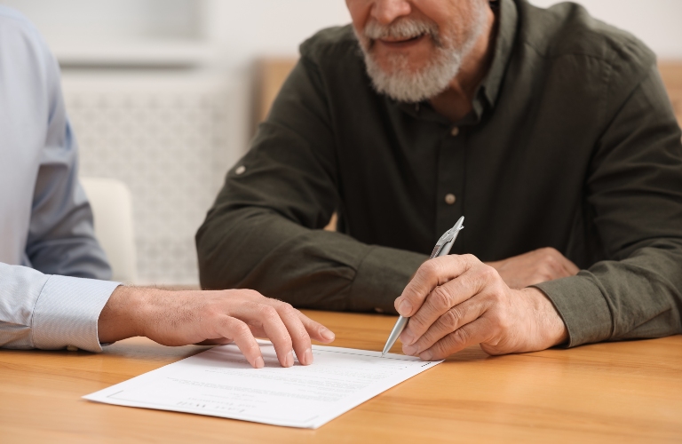 lawyer showing senior man where to sign document