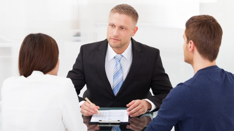 Rear view of young couple consulting with lawyer about divorce
