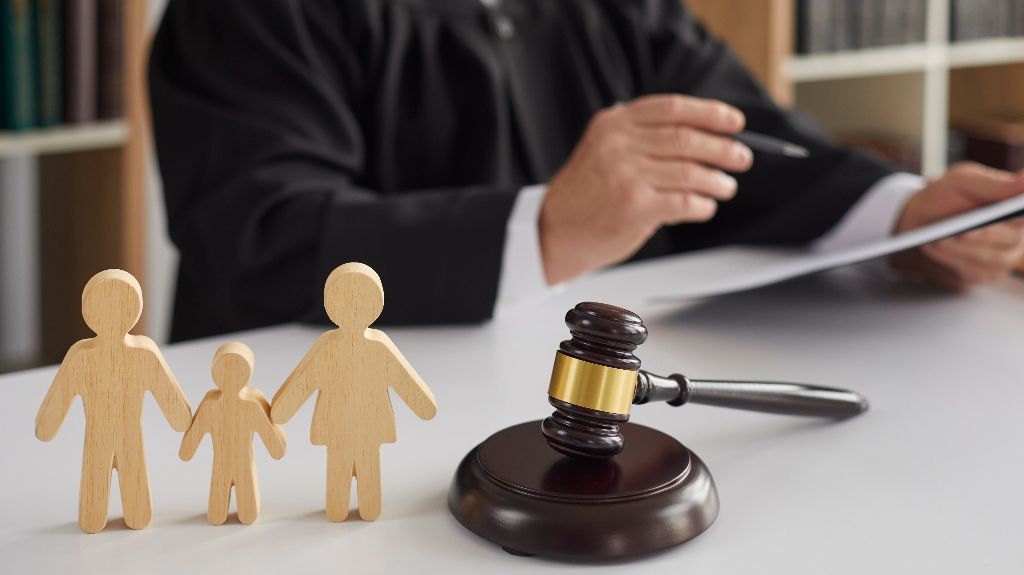 Wooden figurines of family with child and judge's gavel