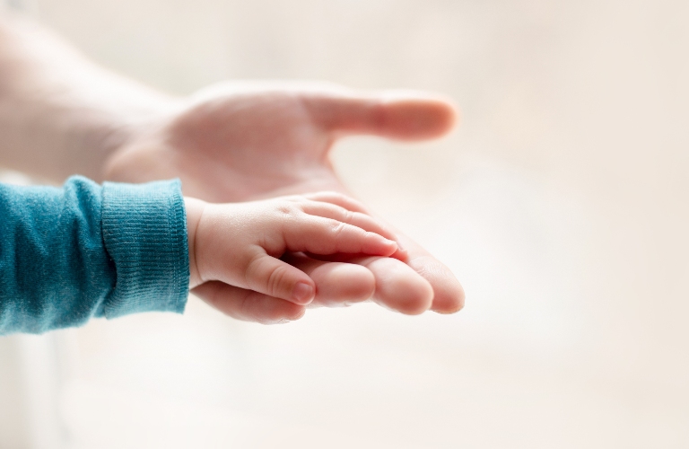 father holds the hand of a small child