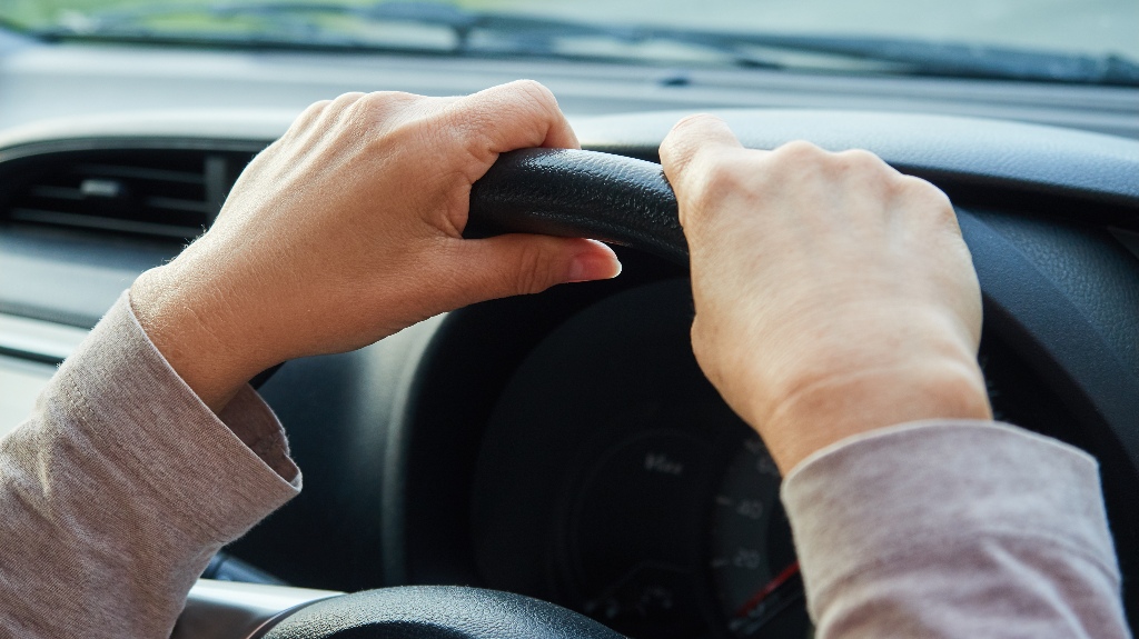 Woman's hands on the steering wheel