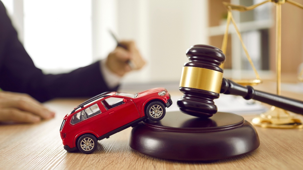 Little red toy automobile and judge's gavel