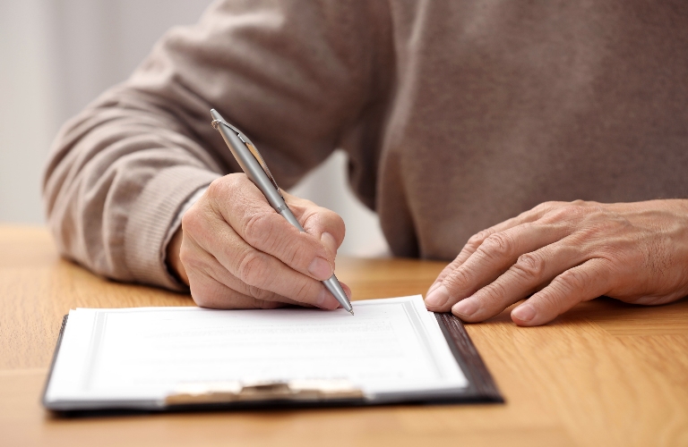 Senior man signing Last Will and Testament