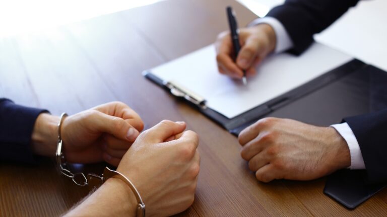 Police officer interrogating criminal in handcuffs